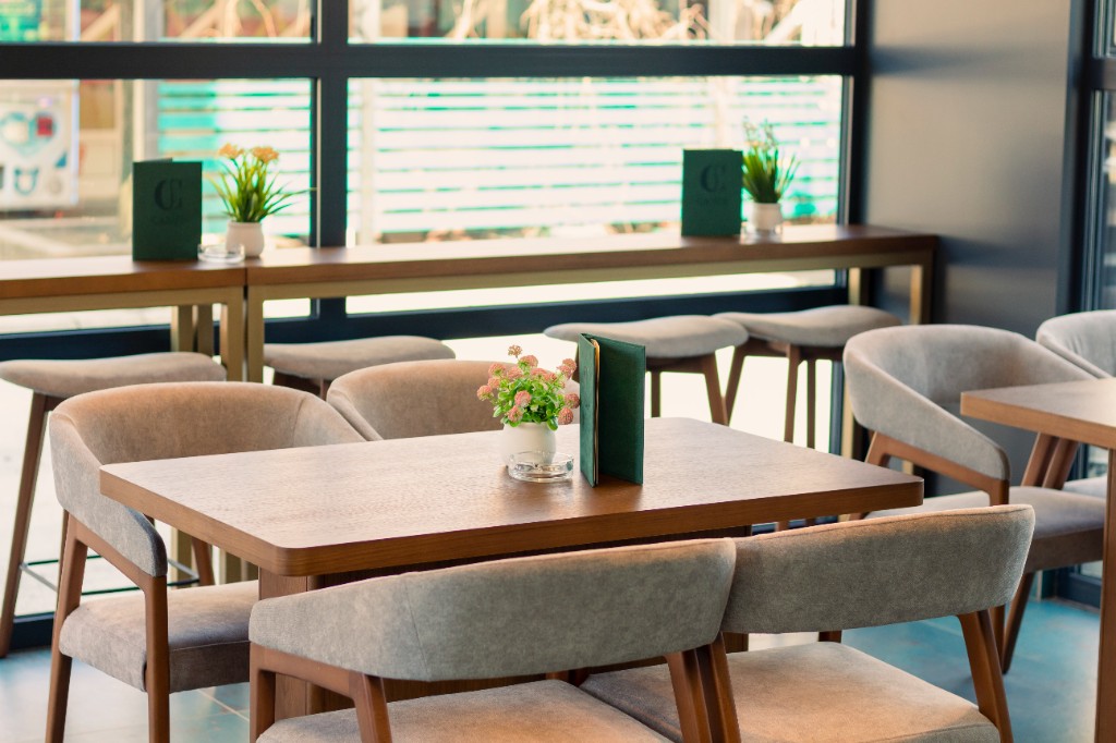 Prostor za jelo sa drvenim stolom i bar stolicama pored prozora.